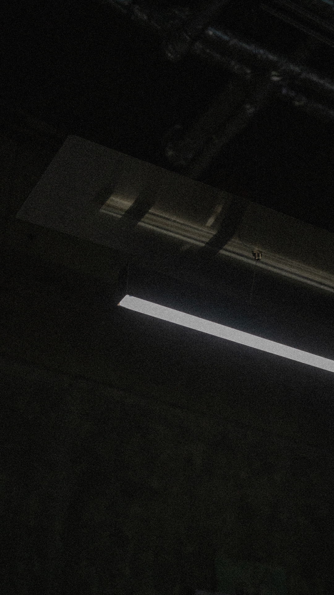 A hard bar of daylight falling across a dark polished floor.